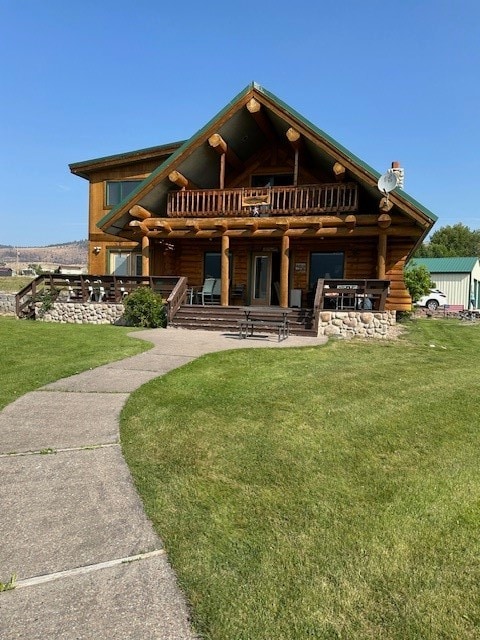 rear view of house featuring covered porch and a lawn