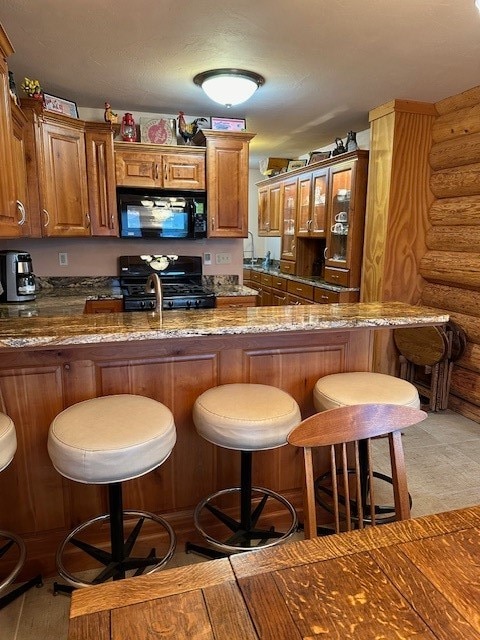 bar featuring log walls, black appliances, dark stone counters, and light wood-type flooring