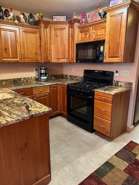 kitchen with dark stone countertops and black appliances