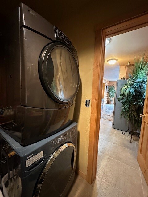 laundry area featuring stacked washer / drying machine