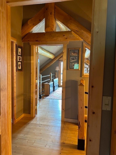 hall with vaulted ceiling with beams and light wood-type flooring