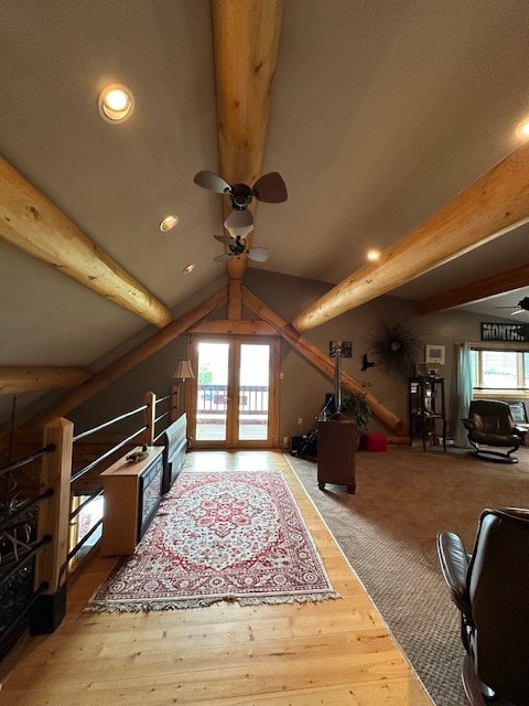 additional living space featuring ceiling fan, wood-type flooring, and vaulted ceiling with beams