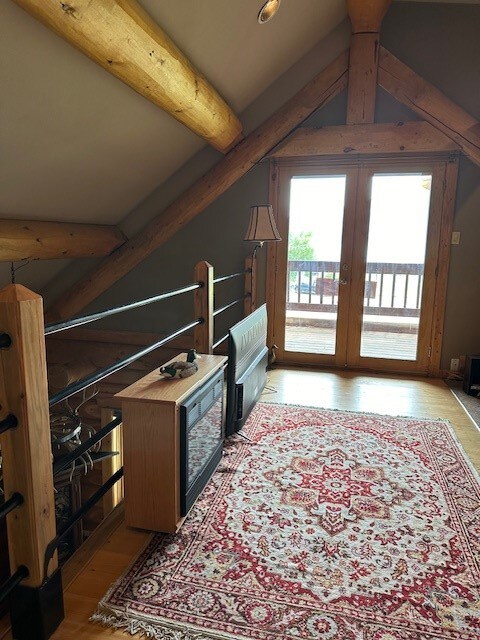 additional living space with vaulted ceiling with beams and french doors