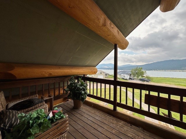 wooden terrace featuring a yard and a water and mountain view