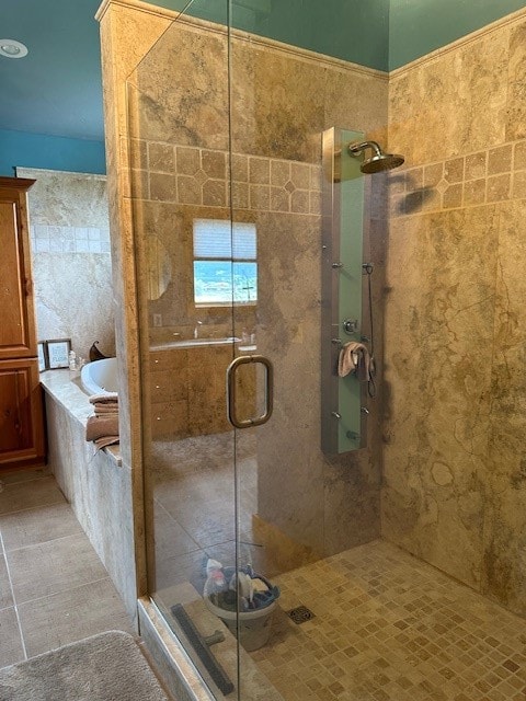 bathroom with tile patterned flooring, tile walls, and separate shower and tub