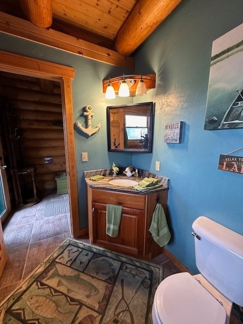 bathroom with toilet, tile patterned flooring, beamed ceiling, wooden ceiling, and vanity