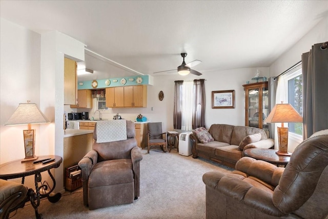 carpeted living room featuring ceiling fan and sink