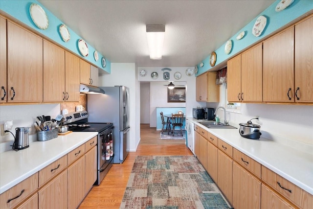 kitchen featuring sink, stainless steel electric range, light hardwood / wood-style floors, a textured ceiling, and light brown cabinets