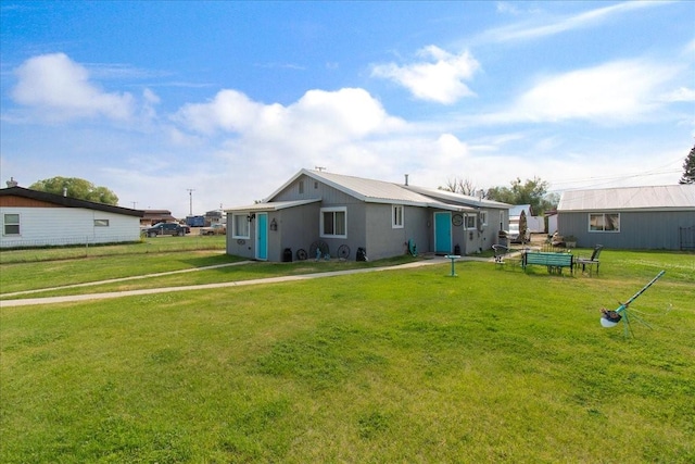 rear view of house featuring a lawn