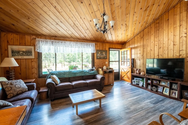 living area with wood walls, a notable chandelier, vaulted ceiling, and wooden ceiling