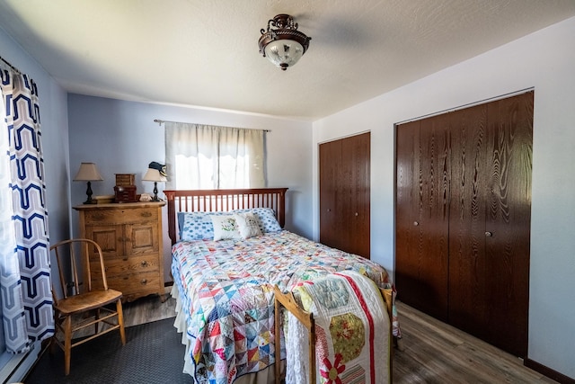 bedroom with two closets and wood finished floors