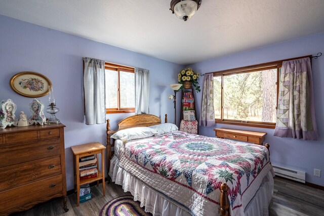 bedroom featuring baseboards, a baseboard radiator, and wood finished floors