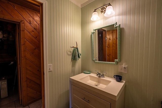bathroom with vanity, ornamental molding, and tile patterned flooring