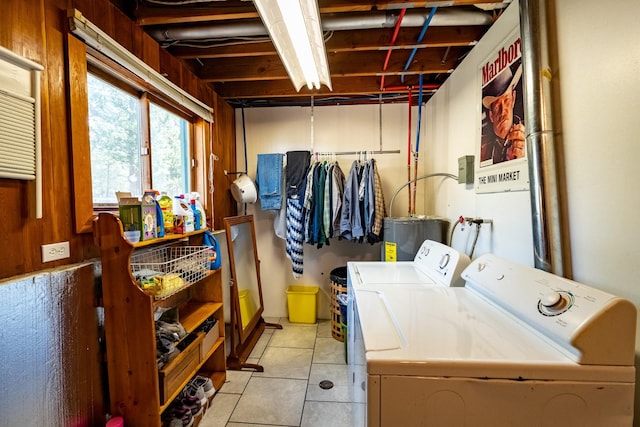 laundry room featuring laundry area, independent washer and dryer, light tile patterned floors, and water heater