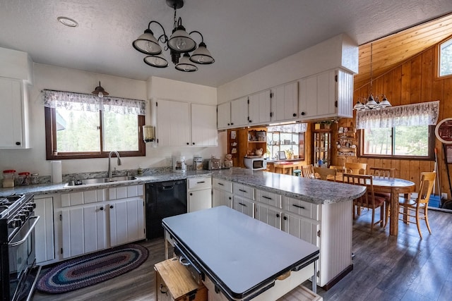 kitchen with a peninsula, dark wood-type flooring, a chandelier, a sink, and black appliances