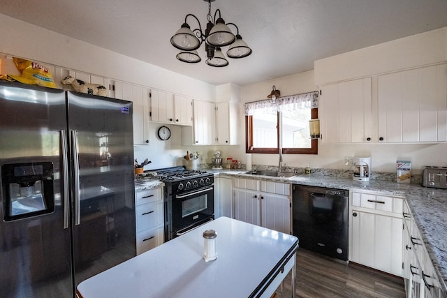 kitchen featuring dark wood-style flooring, black appliances, white cabinets, a sink, and a notable chandelier