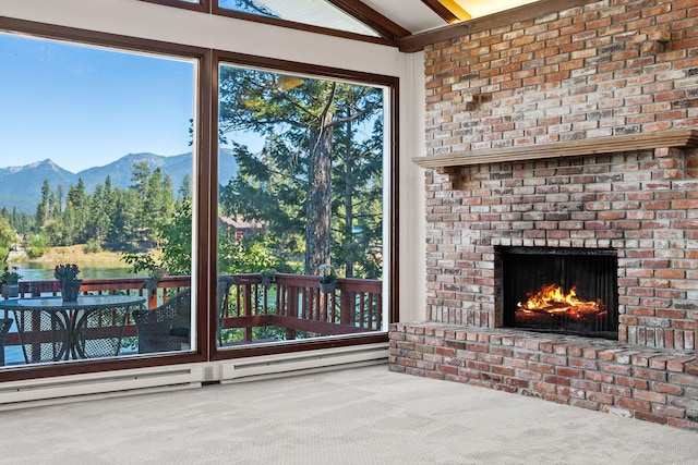 unfurnished living room featuring a brick fireplace, carpet flooring, a mountain view, and lofted ceiling with beams