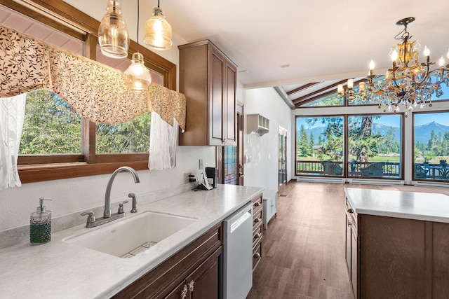 kitchen with dishwasher, light countertops, hanging light fixtures, and a sink