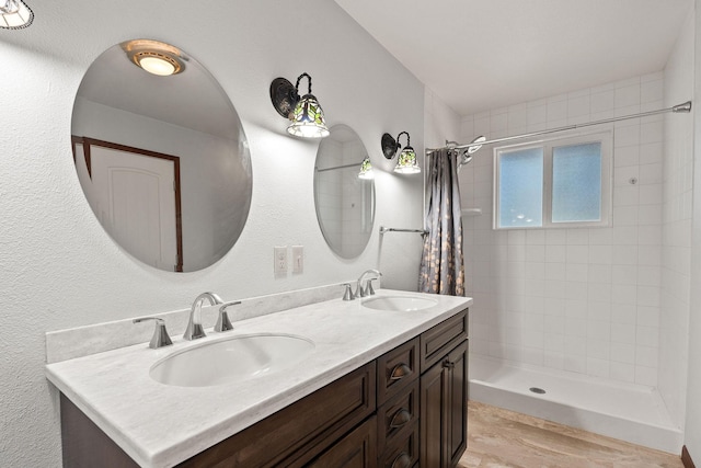 548 W Village Dr, Bigfork, MT 59911 - full bath with tiled shower, double vanity, and wood finished floors