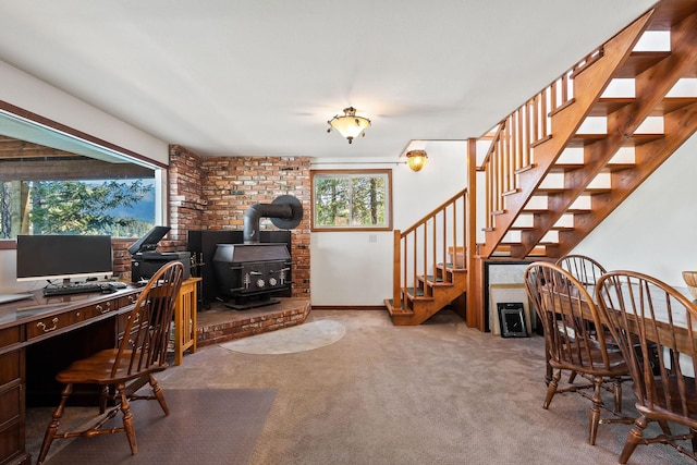 office area featuring a wood stove, baseboards, and carpet floors