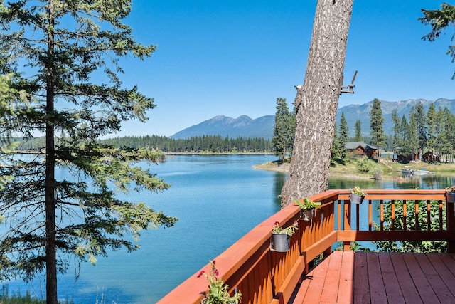 wooden deck with a water and mountain view