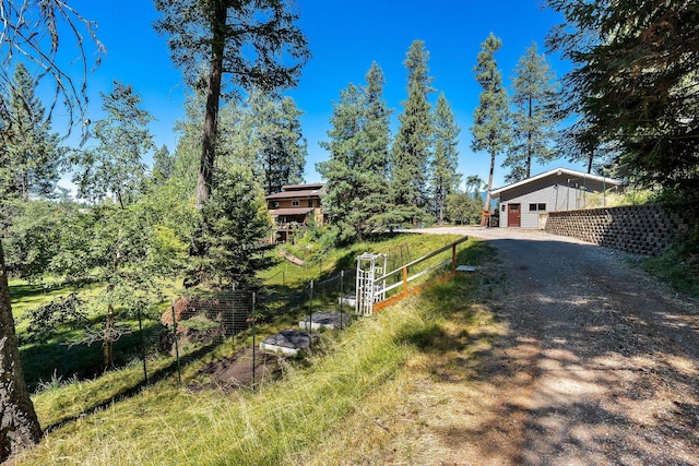 exterior space featuring dirt driveway and fence