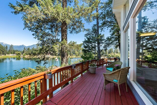 deck featuring a water and mountain view and a grill