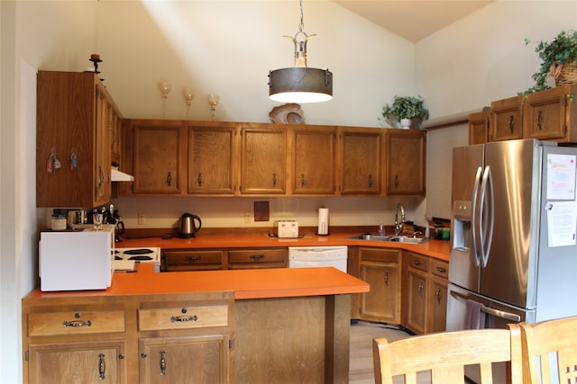 kitchen with hanging light fixtures, light wood-type flooring, white appliances, sink, and lofted ceiling