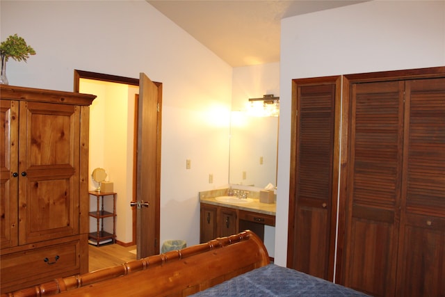 bedroom featuring a closet, sink, ensuite bath, and light wood-type flooring