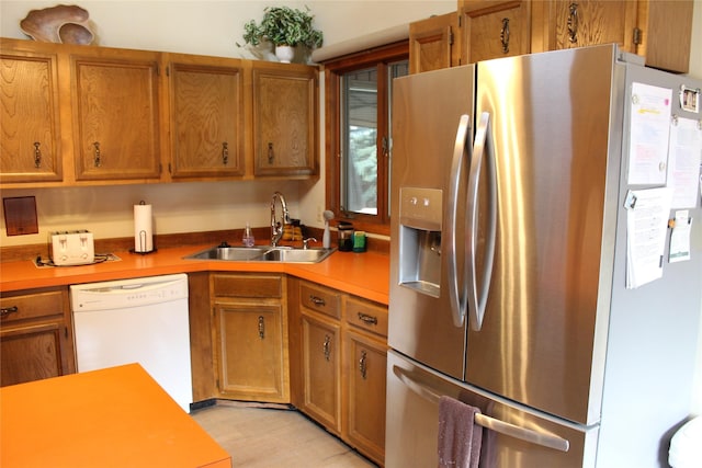 220 Fox Farm Dr, Whitefish, MT 59937 - kitchen with stainless steel fridge with ice dispenser, white dishwasher, brown cabinetry, light countertops, and light wood-style flooring