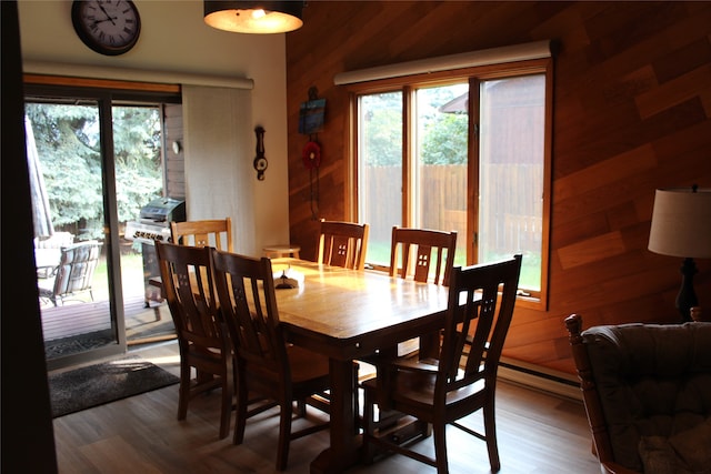 dining room with wooden walls and wood-type flooring