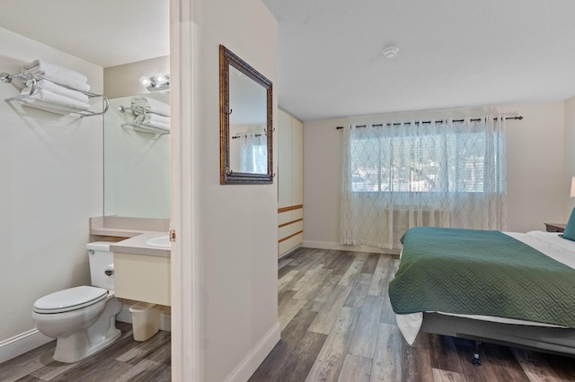 bedroom with baseboards and wood finished floors