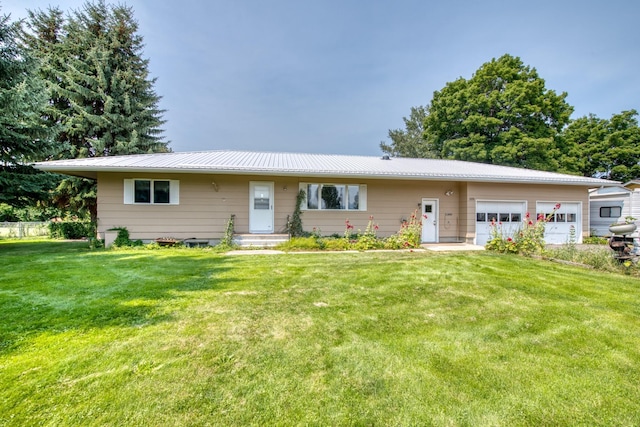 ranch-style house featuring a garage, metal roof, and a front lawn