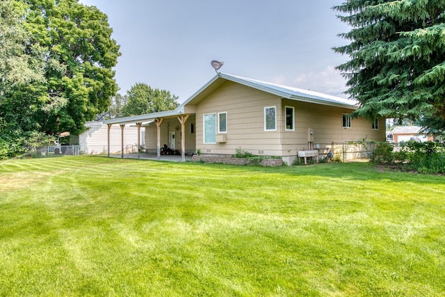 rear view of house featuring a patio area, a yard, and fence