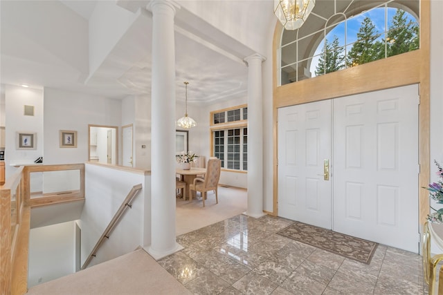 entryway with decorative columns and an inviting chandelier