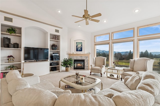 carpeted living area featuring vaulted ceiling, recessed lighting, built in shelves, a ceiling fan, and a fireplace
