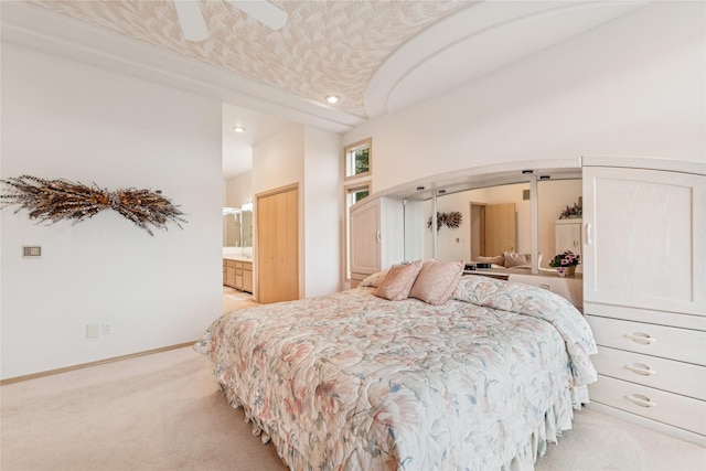 bedroom with baseboards, arched walkways, connected bathroom, ceiling fan, and light carpet