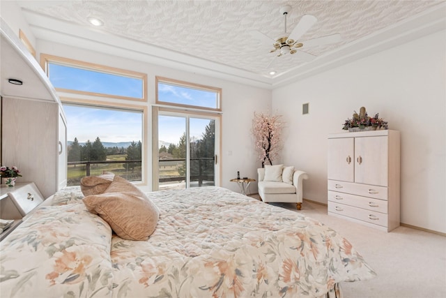 carpeted bedroom featuring a textured ceiling, baseboards, ceiling fan, access to outside, and a raised ceiling