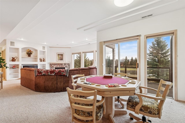 dining area featuring visible vents, a fireplace, recessed lighting, built in features, and light colored carpet