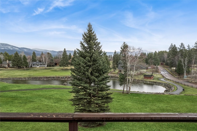 view of community with a lawn and a water and mountain view