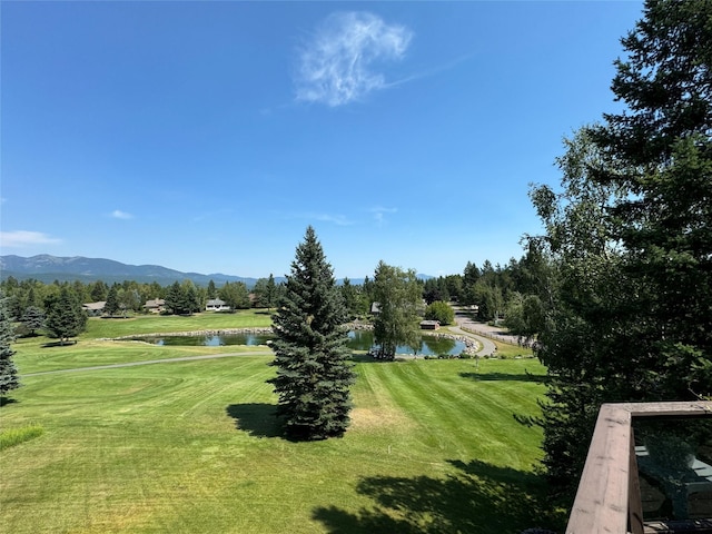 view of home's community with a water and mountain view and a lawn