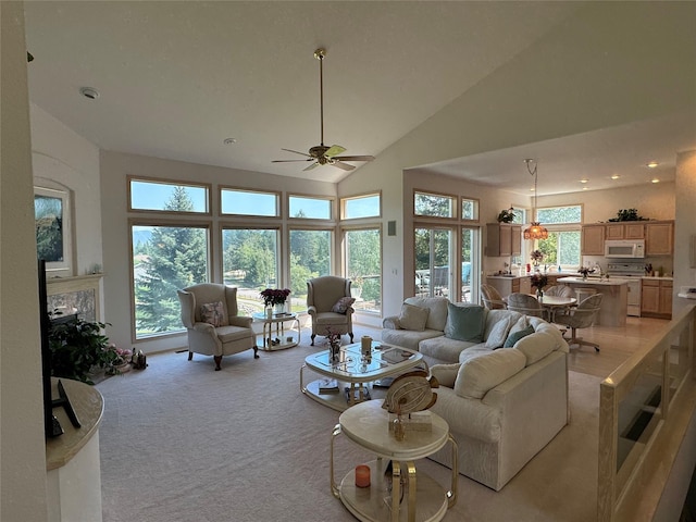 living room featuring high vaulted ceiling, light colored carpet, and ceiling fan