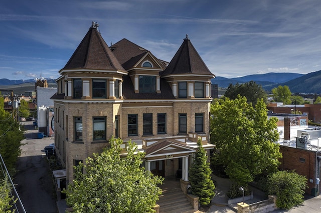 victorian home featuring brick siding and a mountain view