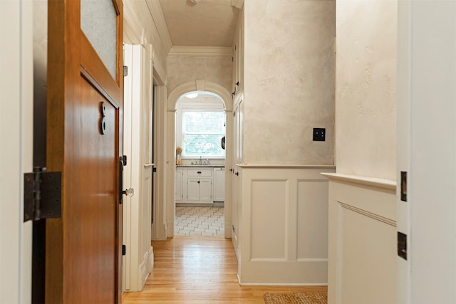 hallway featuring light tile patterned flooring and ornamental molding