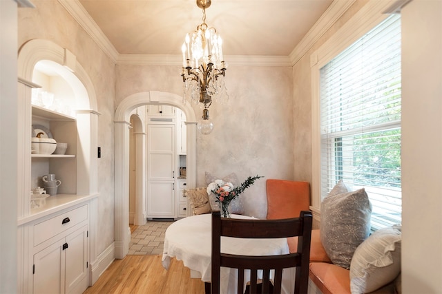 dining area featuring a notable chandelier, light hardwood / wood-style flooring, and crown molding