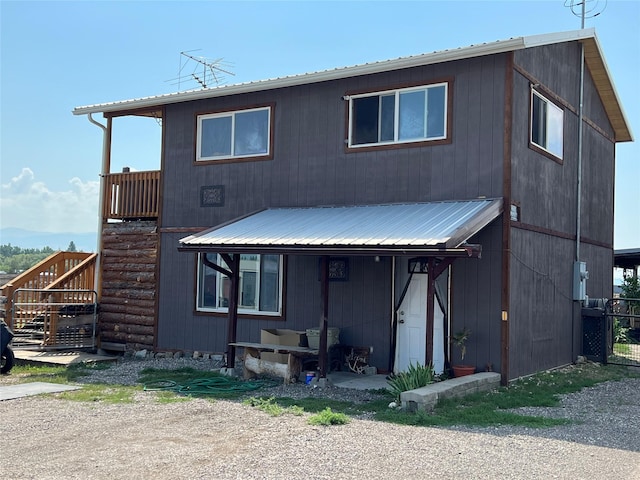 view of front of house featuring stairs and metal roof