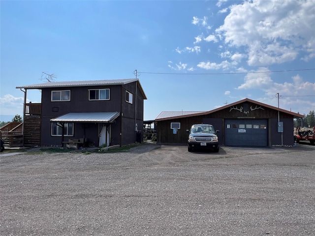 view of front of home with a garage, metal roof, and stairway