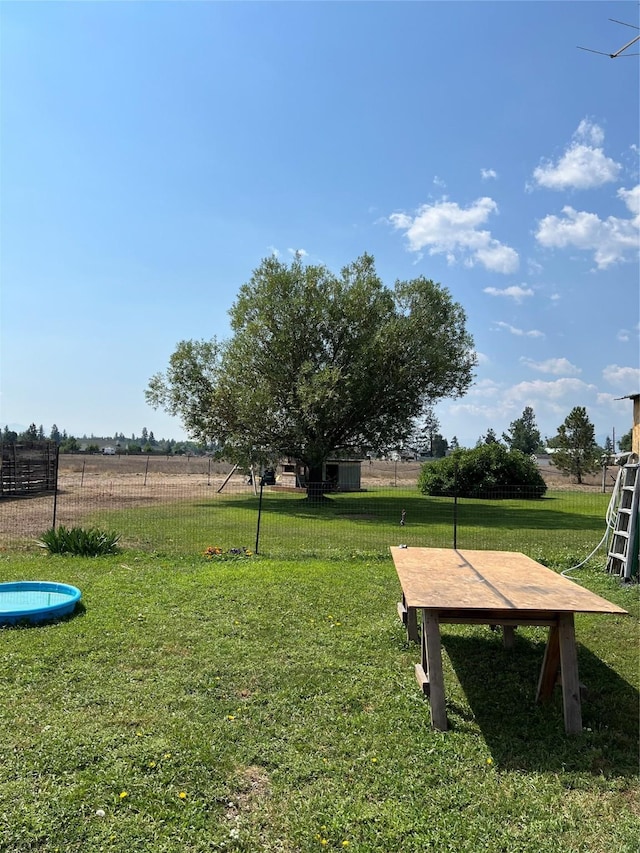 view of home's community with fence and a yard