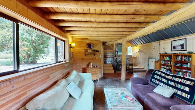 living room featuring dark hardwood / wood-style floors, wood walls, beam ceiling, and a wealth of natural light