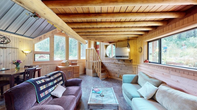 living room with vaulted ceiling with beams, wooden ceiling, and wood walls